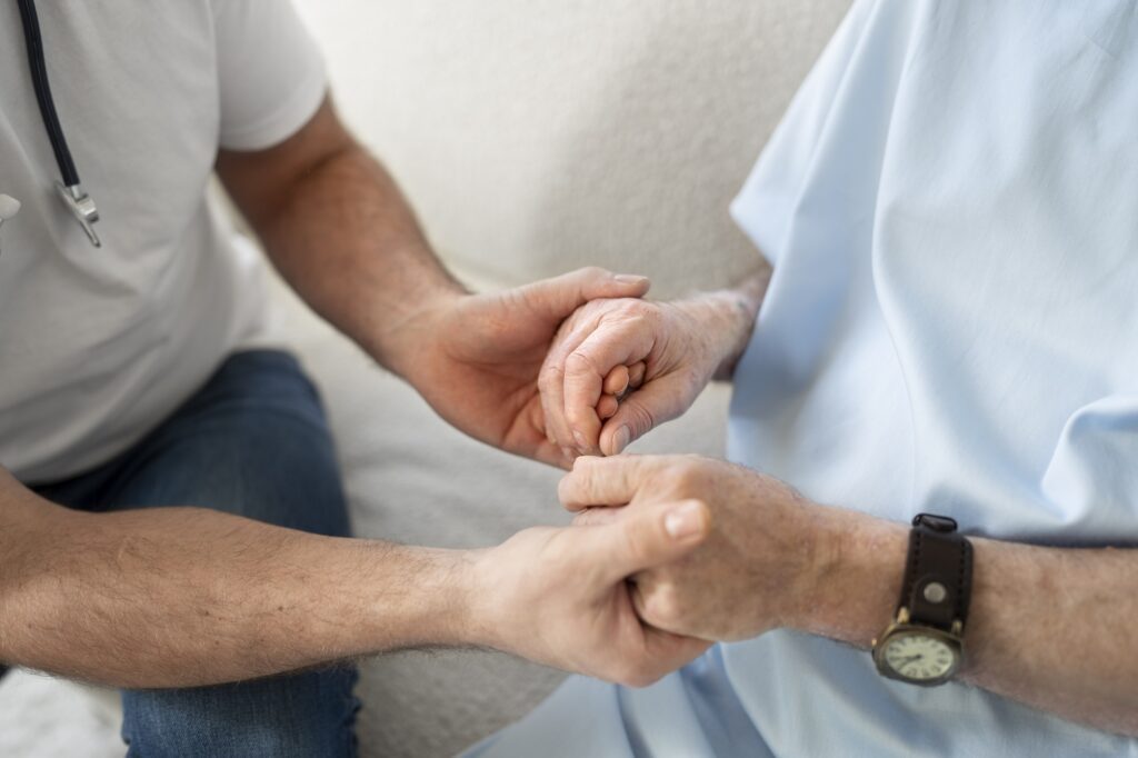 médico segurando a mão de um paciente idoso